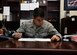 U.S. Air Force Airman First Class Alexander Bugerenko, 97th Air Mobility Wing Military Justice paralegal, simulates working on an Article 15 checklist, Nov.1, 2016, at Altus Air Force Base, Okla. The Base Legal Office helps base members with legal matters and services as well as advising commanders on legal proceedings. (U.S. Air Force Photo by Airman Jackson Haddon/ Released)