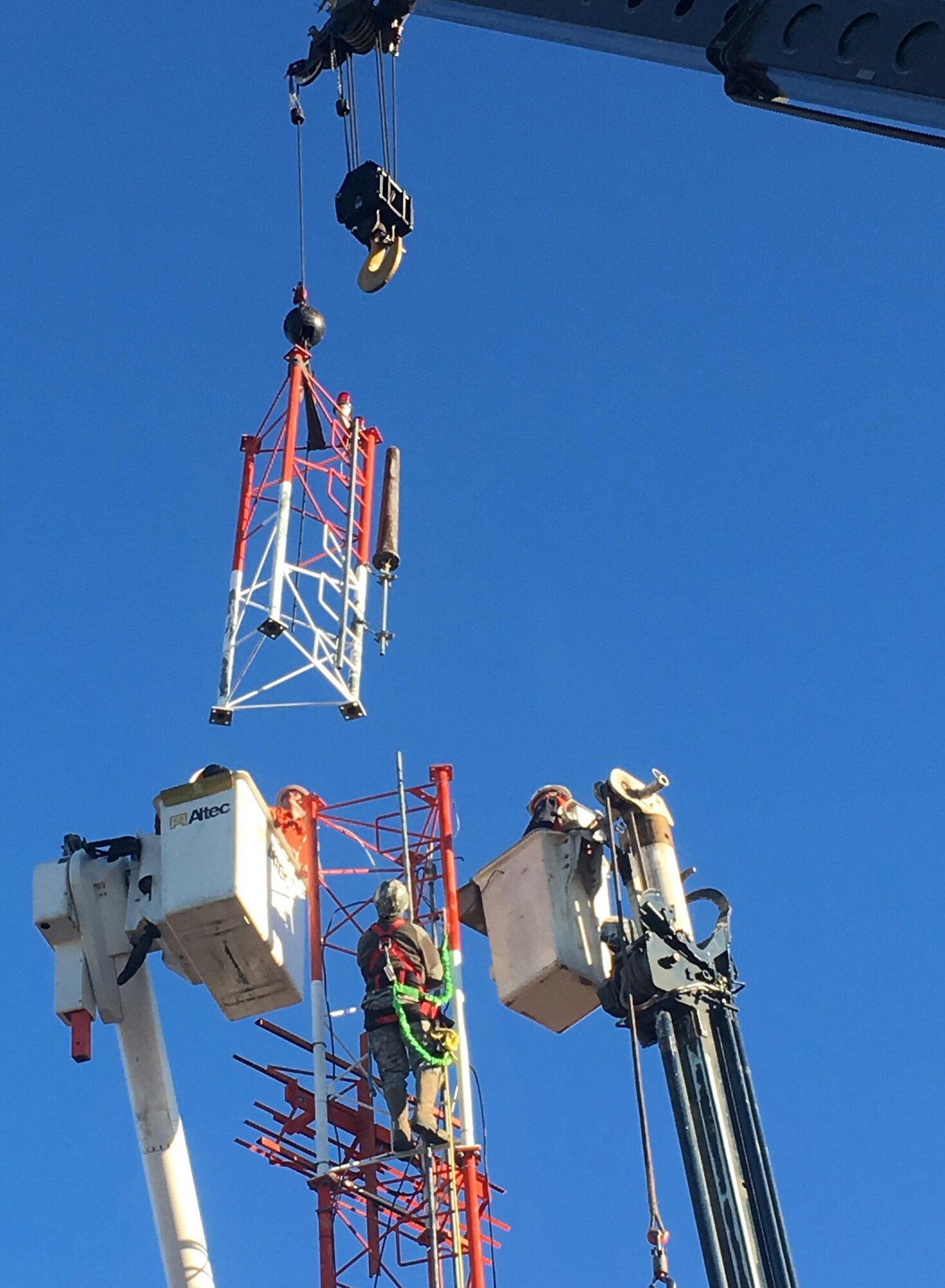 U.S. Air Force Airmen from the 354th Civil Engineer Squadron watch as a crane removes a piece of an antenna mast Oct. 6, 2016, at Eielson Air Force Base, Alaska. This piece will be reused to build a new antenna mast at Andersen Air Force Base, Guam, saving approximately $12,000. (U.S. Air Force photo by Master Sgt. Jennifer Brown)
