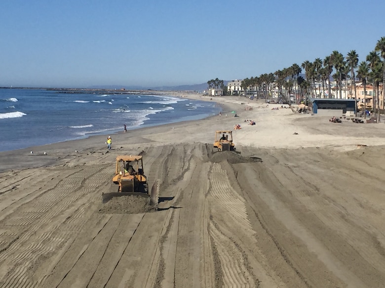 Bulldozers grade the beach next to the Oceanside Pier following completion of the Oceanside Harbor navigational dredging project. The project removed nearly 260,000 cubic yards of material from the harbor's entrance channel, placing it along a 3,000 foot section of beach that provides recreation and helps protect homes and businesses from the ocean.