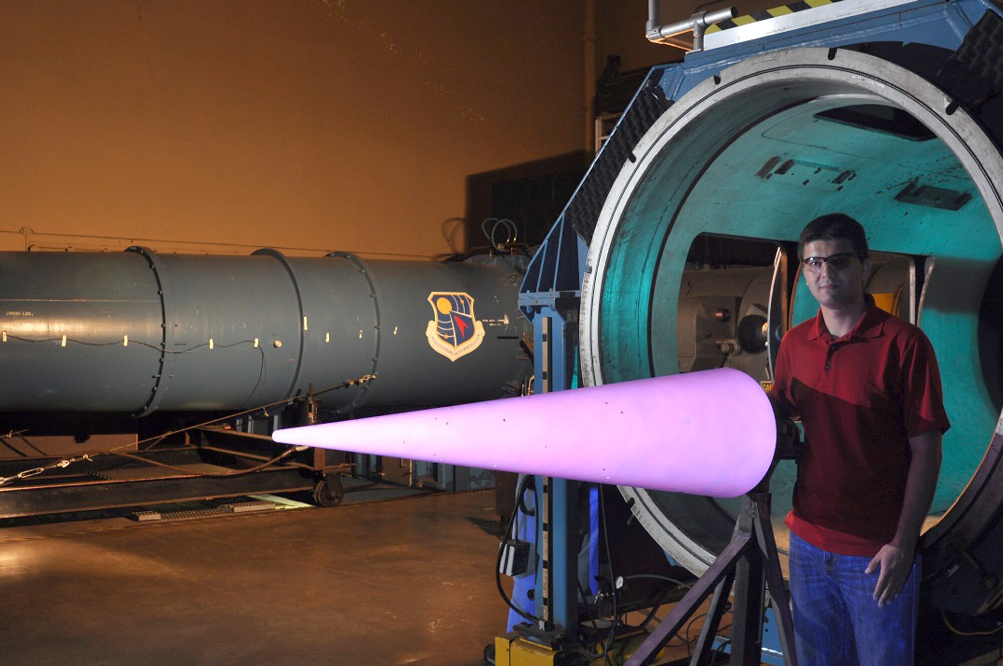 Tunnel 9 project engineer George Moraru examines the illuminated temperature sensitive paint coating on a large 7-degree cone prior to the test program. Moraru will speak as part of an upcoming International Test and Evaluation Association panel on his experiences in testing at Tunnel 9. (U.S. Air Force photo/A.J. Spicer)