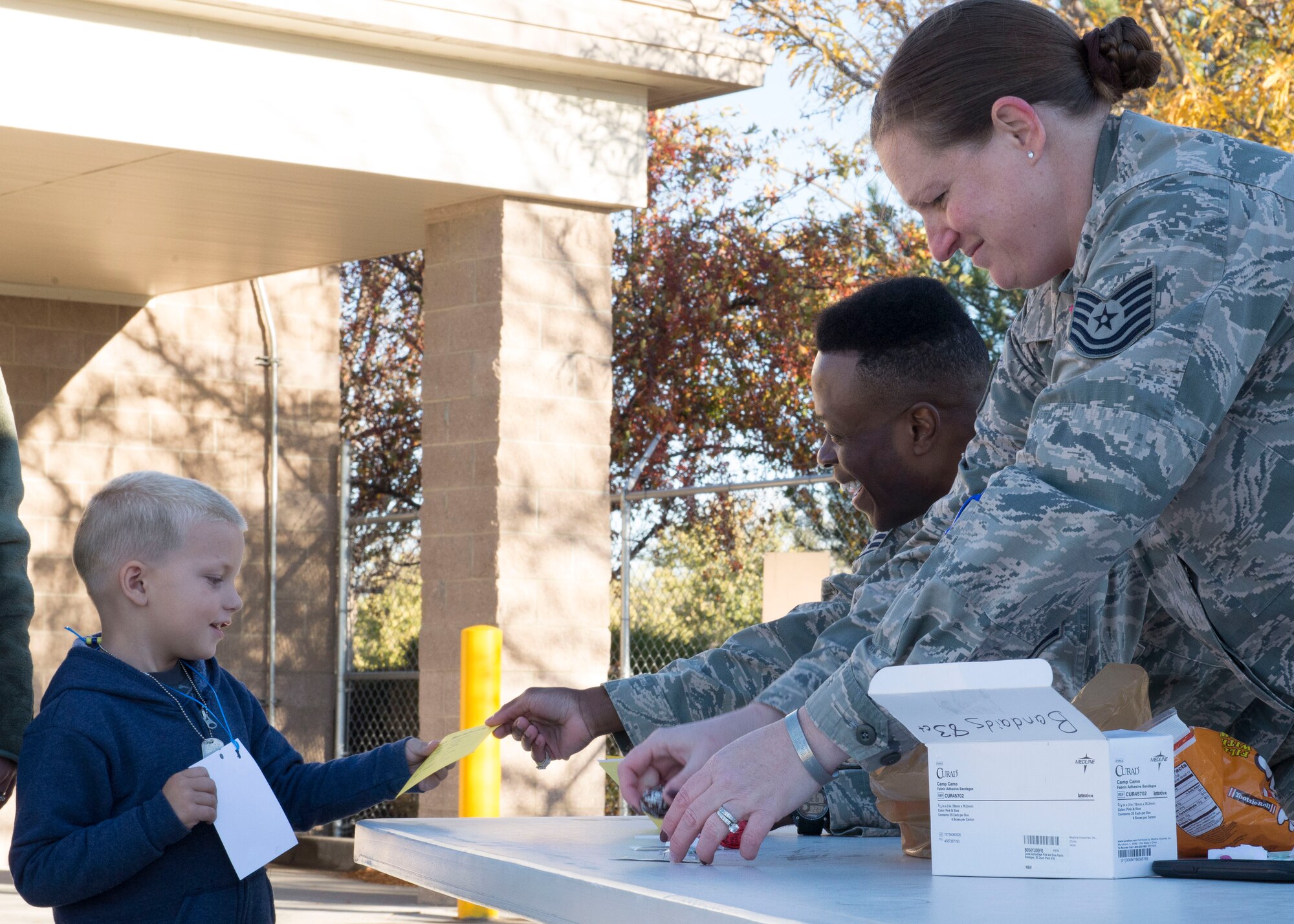 Children get their mock medical forms from the emergency medical technician stand at the Kids Understanding Deployment Operations day Oct. 21, 2016, at Mountain Home Air Force Base, Idaho. The event gave deployed service members' kids the opportunity to experience what their parents do before deploying. (U.S. Air Force photo by Airman Jeremy D. Wolff/Released)