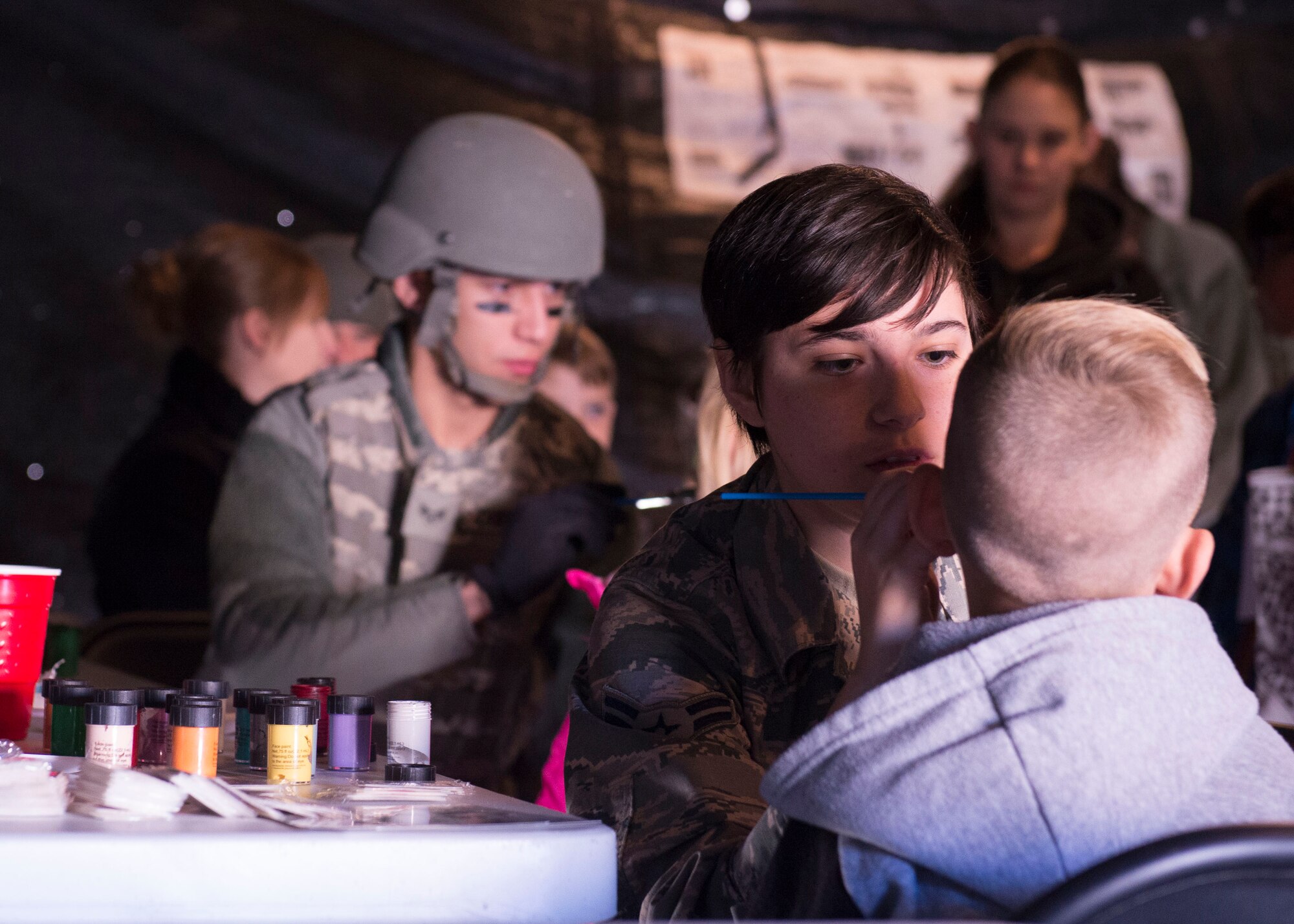 An airman paints a child's face at the Kids Understanding Deployment Operations day Oct. 21, 1016, at Mountain Home Air Force Base, Idaho. During the day, kids got a chance to have their faces painted and taste Meals Ready to Eat. (U.S. Air Force photo by Airman Jeremy D. Wolff/Released)