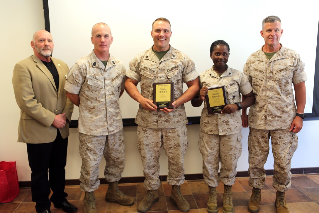 Essay winners Sgt. Grant Kollinger and Cpl. Jackie Madhava display their plaques while posing with Lt. Gen. Lewis Craparotta, commanding general, I Marine Expeditionary Force (right), Sgt. Maj. Frank Pulley (left), and Sgt. Major Bradley Kasal, during a luncheon for the “Protect What You’ve Earned” essay contest at Marine Corps Base Camp Pendleton, Calif., Oct. 14, 2016. Madhava received first and Kollinger received third place out of more than 40 contestants. (U.S. Marine Corps photo by Pfc. Gabino Perez)