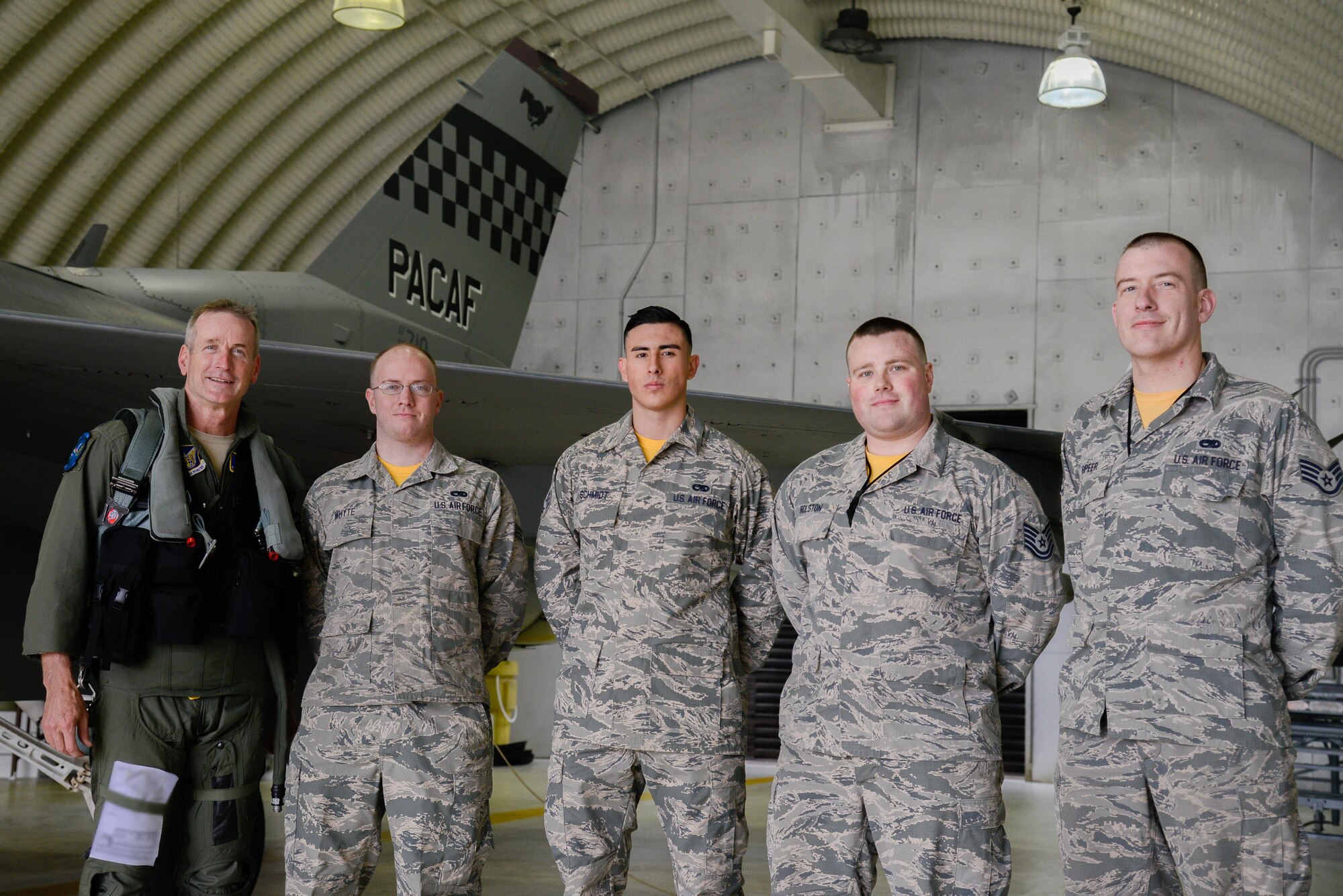 U.S. Air Force Gen. Terrence O’Shaughnessy, Pacific Air Forces commander, poses for a photo with 51st Maintenance Group Airmen after flying in an F-16 Fighting Falcon at Osan Air Base, Republic of Korea, Nov. 4, 2016.  After his flight, O’Shaughnessy rewarded the crew chiefs with his coin for their excellence and contributions to the 51st Fighter Wing mission. (U.S. Air Force photo illustration by Senior Airman Dillian Bamman)