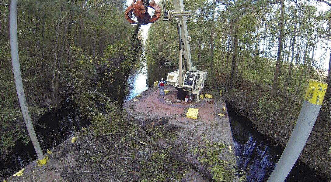 CHESAPEAKE, Va. -- Norfolk District Operations Branch personnel use a crane barge to remove downed trees along the Dismal Swamp Canal's Lake Drummond feeder ditch here October 27, 2016. The trees came down during Hurricane Matthew, which inundated the area with water causing flooding, power outages and downed trees. (U.S. Army photo/Patrick Bloodgood)