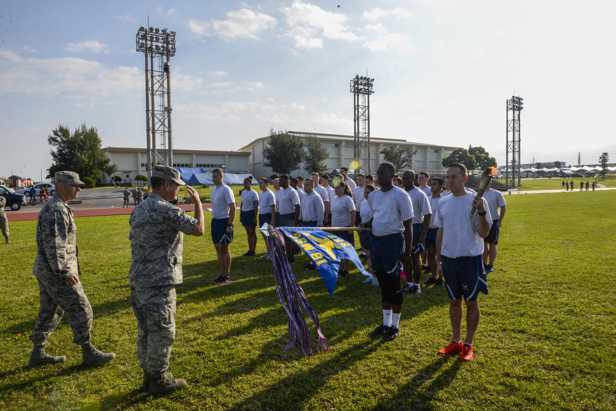 Col. Paul Oldham, 18th Mission Support Group commander, presents a Kadena Special Olympics streamer to the 18th Security Forces Squadron during the annual running of the torch Nov. 4, 2016, at Kadena Air Base, Japan. Roughly 1,000 American volunteers will be paired up with more than 500 local interpreters to support this year’s KSO athletes. (U.S. Air Force photo by Senior Airman Stephen G. Eigel/released)