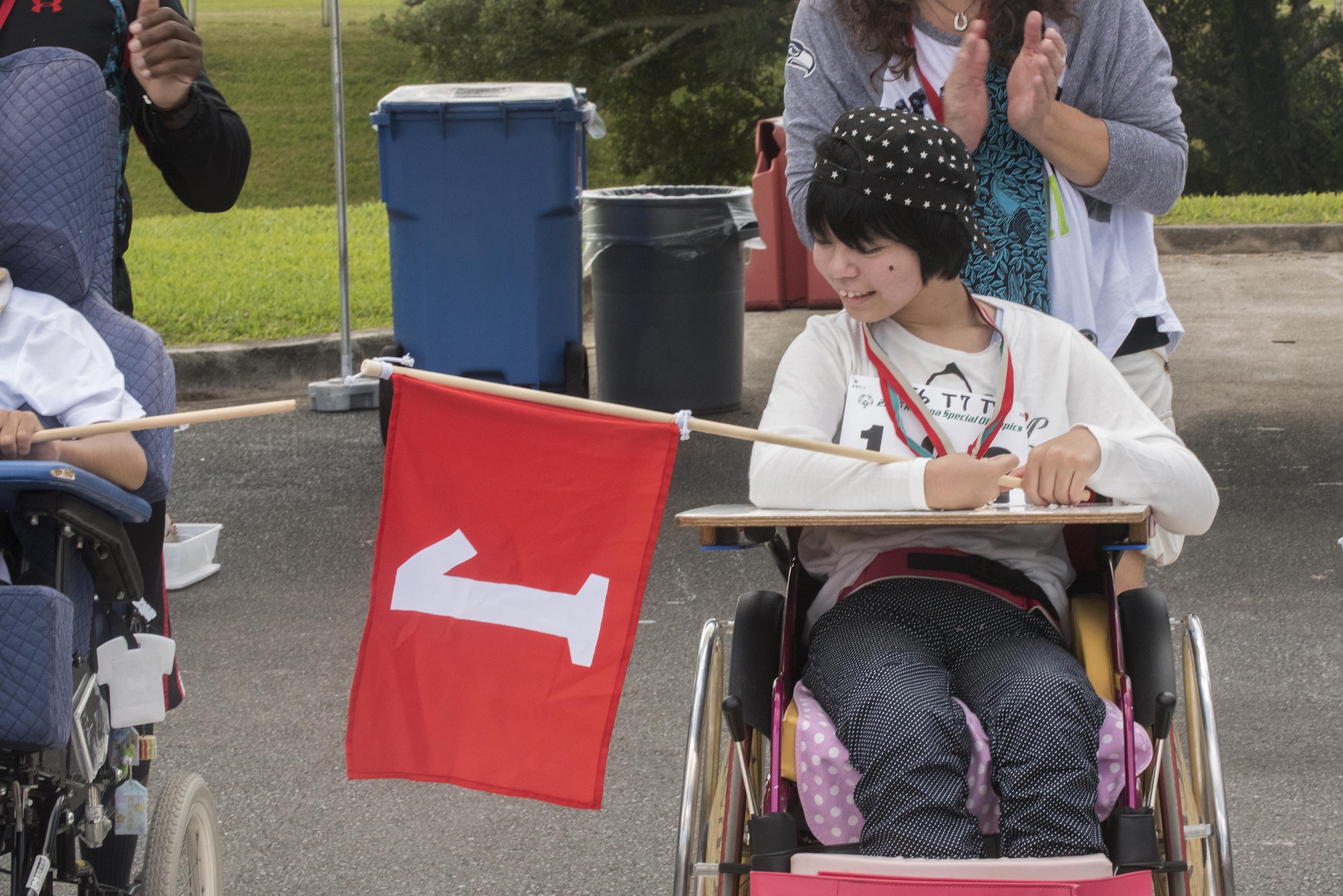 Honoka Nakamura, Kadena Special Olympics athlete, admires her first place flag after winning a wheelchair race Nov. 5, 2016, at Kadena Air Base, Japan. The Kadena Special Olympics celebrates 17 years of partnership with Okinawan athletes and artists who help unite service members with the local community. (U.S. Air Force photo by Airman 1st Class Corey M. Pettis/Released)