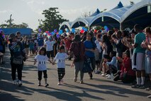 Special-needs athletes and family members walk through a cheering crowd during the Kadena Special Olympics Nov. 5, 2016, at Kadena Air Base, Japan. Before events began, athletes paired with Brave Buddies who are U.S. service members who volunteered to help and encourage special-needs athletes as they participated in different events. (U.S. Air Force photo by Senior Airman Peter Reft/Released)
