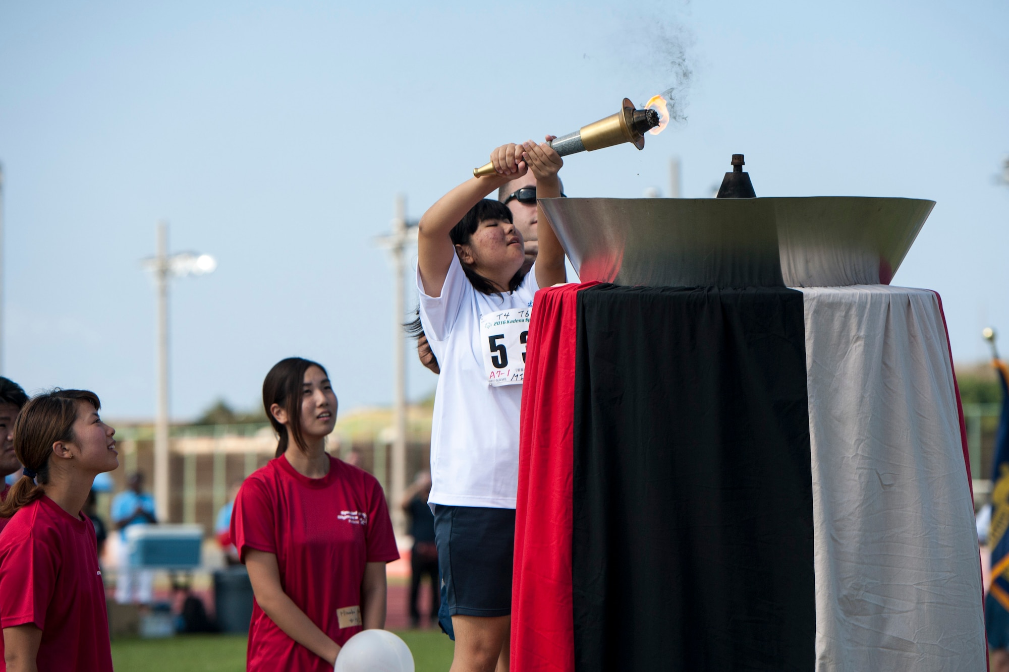 Miyuu, a special-needs athlete, lights the Olympic torch during the Kadena Special Olympics opening ceremony Nov. 5, 2016, at Kadena Air Base, Japan. Since the first time Kadena hosted the games in 2000, volunteers have highlighted inspiring acts of kindness, courage and team spirit from the athletes, family members and volunteers across the island. (U.S. Air Force photo by Senior Airman Peter Reft/Released)
