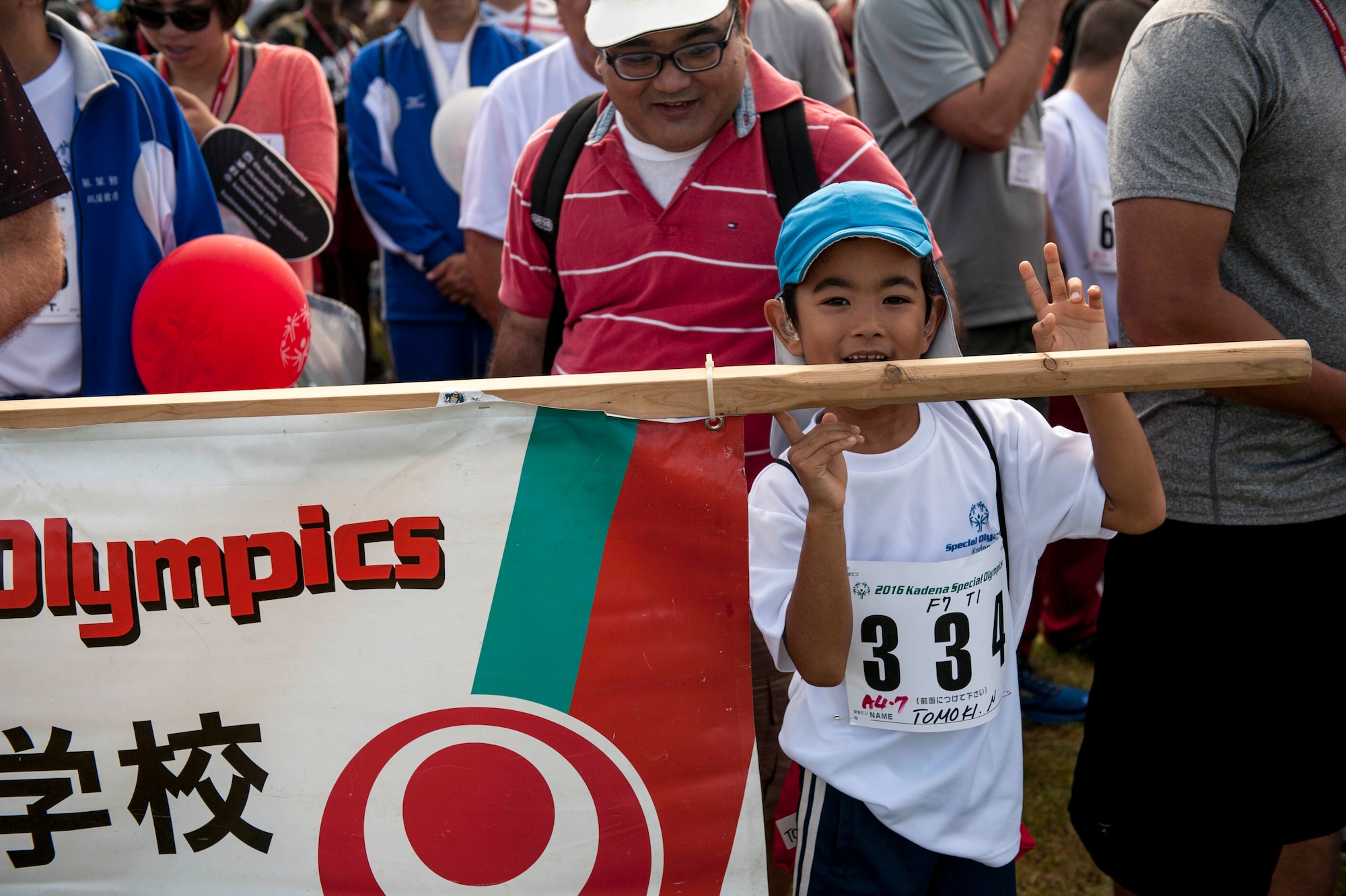 Tomoki, a special-needs athlete, holds up his school sign for a parade formation during the Kadena Special Olympics opening ceremony Nov. 5, 2016, at Kadena Air Base, Japan. The KSO breaks down social barriers and creates an environment of understanding and acceptance for the members of the combined community with physical and intellectual disabilities. (U.S. Air Force photo by Senior Airman Peter Reft/Released)