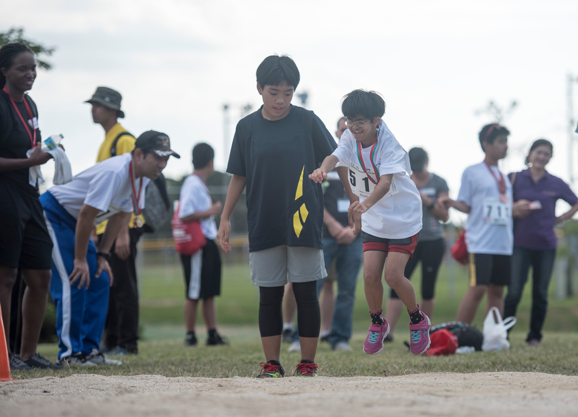 Mio Yabiku, Kadena Special Olympics athlete, competes in the standing long jump event during the Kadena Special Olymics Nov. 5, 2016 at Kadena Air Base, Japan. Thousands of spectators from Japan and the U.S. came out to support approximately 1300 athletes and artists participating in the 17th annual KSO games and art show. (U.S. Air Force photo by Senior Airman Omari Bernard/Released)