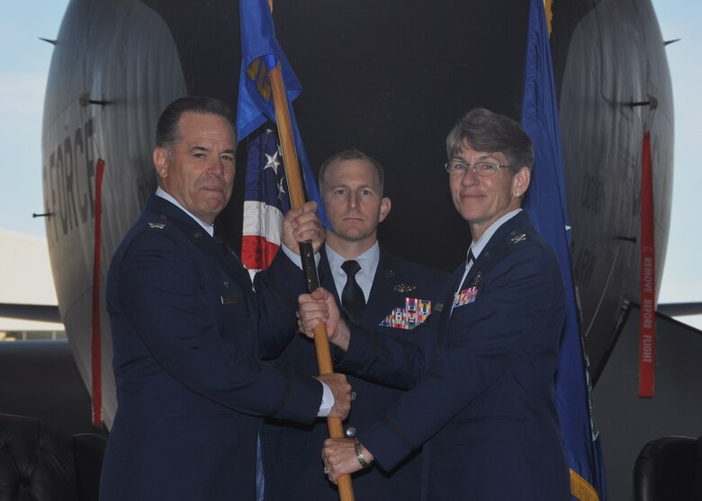 Col. Mark S. Larson, left,  931st Air Refueling Wing commander, passes the 931st Operations Group guidon to Col. Caroline B. Evernham, incoming 931 OG commander, during an assumption of command ceremony Nov. 5, 2016, McConnell Air Force Base, Kan. The passing of the guidon symbolizes the transfer of authority from one commander to the next. (U.S. Air Force photo by Senior Airman Preston Webb)