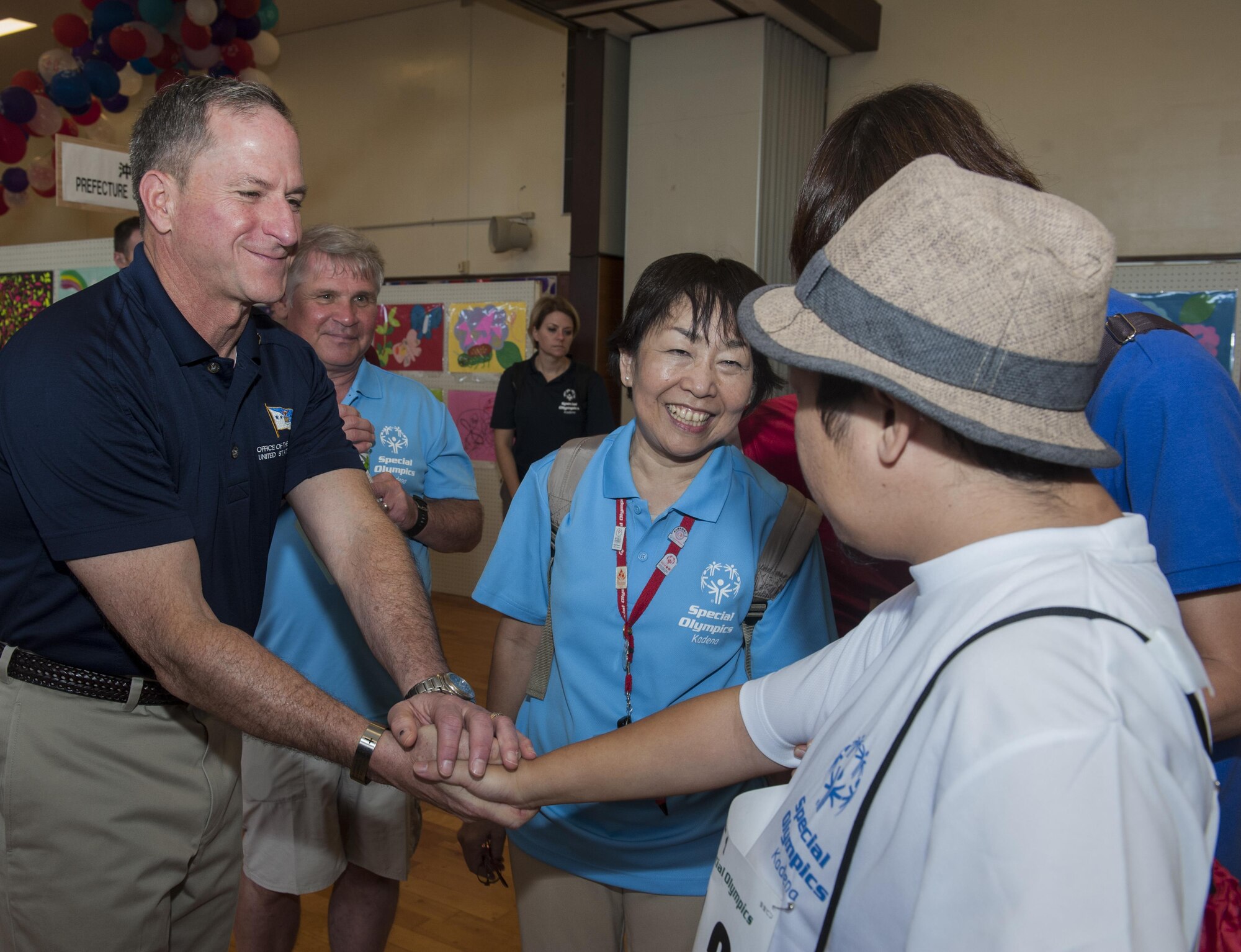 Air Force Chief of Staff Gen. Dave Goldfein welcomes a Kadena Special Olympics athlete at the KSO art exhibit Nov. 5, 2016, at Kadena Air Base, Japan. The KSO was established by the 18th Wing commander in 2000 as an avenue to build relations with the local communities and government representatives while providing a meaningful activity for members of the special needs community on Okinawa. (U.S. Air Force photo by Senior Airman Lynette M. Rolen/Released)