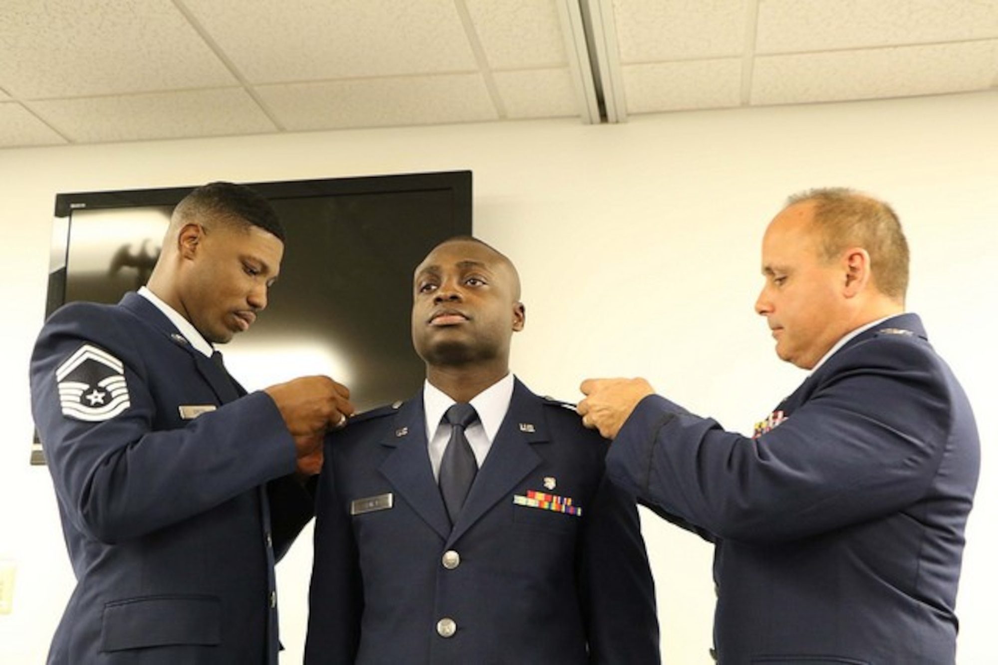 1st Lt. Carl Sidney 45th Aeromedical Evacuation Squadron executive officer, gets lieutenant bars placed on the lapels of his service dress uniform by Senior Master Sgt. Darnell Green 927th Aeromedical Staging Training Squadron superintendent and Col. James Palmisano 45th Aeromedical Evacuation Squadron commander at MacDill Air Force Base, FL on Nov. 5, 2016. Sidney joined the Air Force Reserve in 2013. (U.S. Air Force photo by Senior Airman Xavier Lockley)