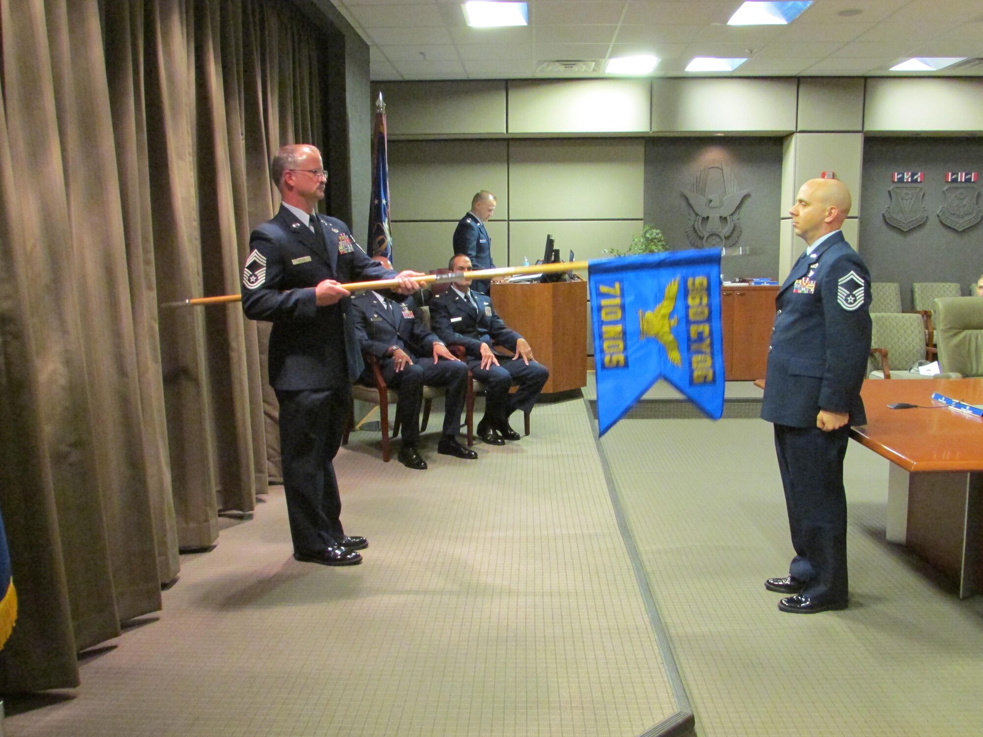 Chief David Miller, 710th Network Operations Squadron superintendent, holds the newly unfurled guidon, as Senior Master Sgt. James Abel, 710th Network Operations Squadron First Sergeant, looks on. The unit was activated during a ceremony at Robins Air Force Base, Ga., Nov. 6. (U.S. Air Force photo by 2nd. Lt. Michael Wisniewski)