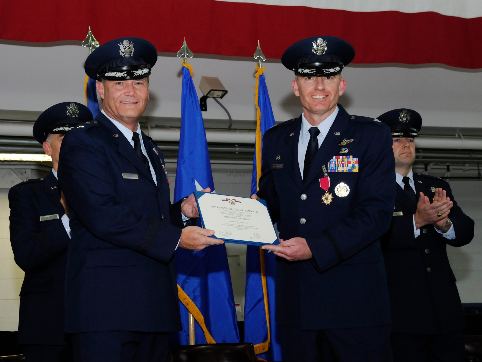 U.S. Air Force Brig. Gen. Michael E. Stencel, The Adjutant General of Oregon, left, presents The Legion of Merit certificate to Col. Paul T. Fitzgerald, the outgoing 142nd Fighter Wing commander, right, during the 142nd Fighter Wing change of command ceremony, Portland Air National Guard Base, Ore., Nov. 6, 2016. (U.S. Air National Guard photo by Tech. Sgt. John Hughel, 142nd Fighter Wing Public Affairs) 