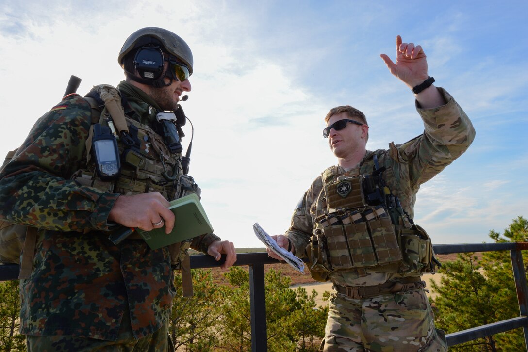 From right, U.S. Air Force Capt. Keith Giamberardino, Joint Terminal Attack Controller (JTAC) with the 227th Air Support Operations Squadron (ASOS), and German armed forces JTAC 1st Lt. Marius Sokol discuss areas for improvement after close air support (CAS) training with New Jersey Air National Guard F-16 fighter jets from the 177th Fighter Wing at the Warren Grove Bombing Range in Ocean County, N.J. on Oct. 26, 2016. German armed forces JTACs partnered with the New Jersey Air National Guard's 227th ASOS for a second time in 2016 for a five day combined training exercise which included the CAS training with F-16s and training in the 227th's state of the art $1.2 million Air National Guard Advanced JTAC Training System.  (U.S. Air National Guard photo by Master Sgt. Andrew J. Moseley/Released)