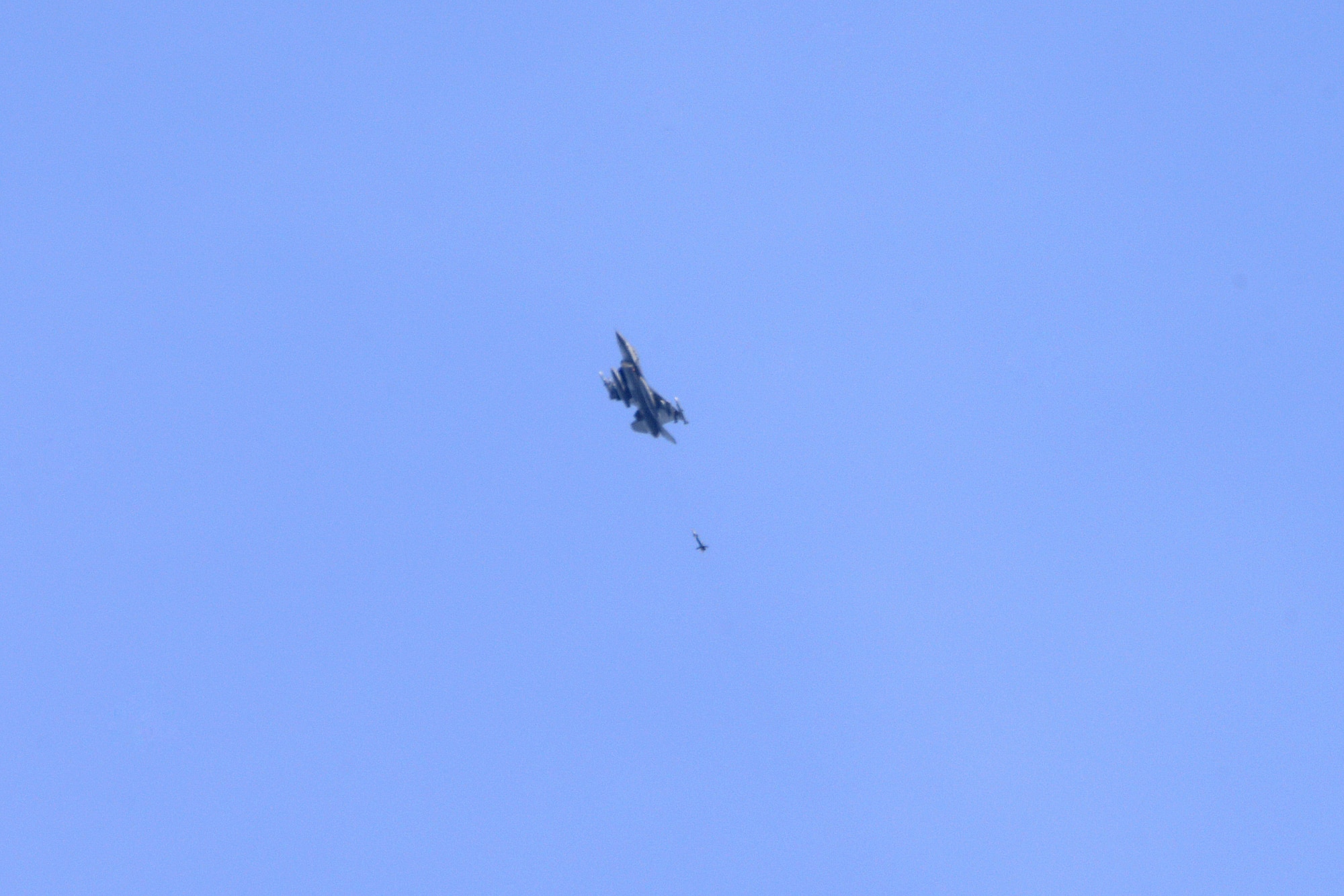 A picture of a U.S. Air Force F-16 Fighting Falcon releasing an inert GBU-12 practice bomb.