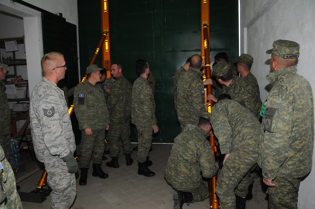 Technical Sgt. Alan Pick, Iowa National Guard’s 185th Air Refueling Wing, watches members of the Kosovo Security Forces Civil Protection unit construct their new lightweight aluminum shoring equipment used to stabilize collapsing walls on October 21, 2016 at their base in Pomosoztin, Kosovo. Training on use of the equipment was provided by the Guardsmen during the Eagle V exercise which provides KSF the opportunity to train with the Iowa National Guard, NATO forces, U.S. Army Security Advisory Mentorship Training Organization and U.S. Army Europe in order to support the KSF mission of maintaining a safe and secure Kosovo. (U.S. Air National Guard photo by Capt. Jeremy J. McClure)