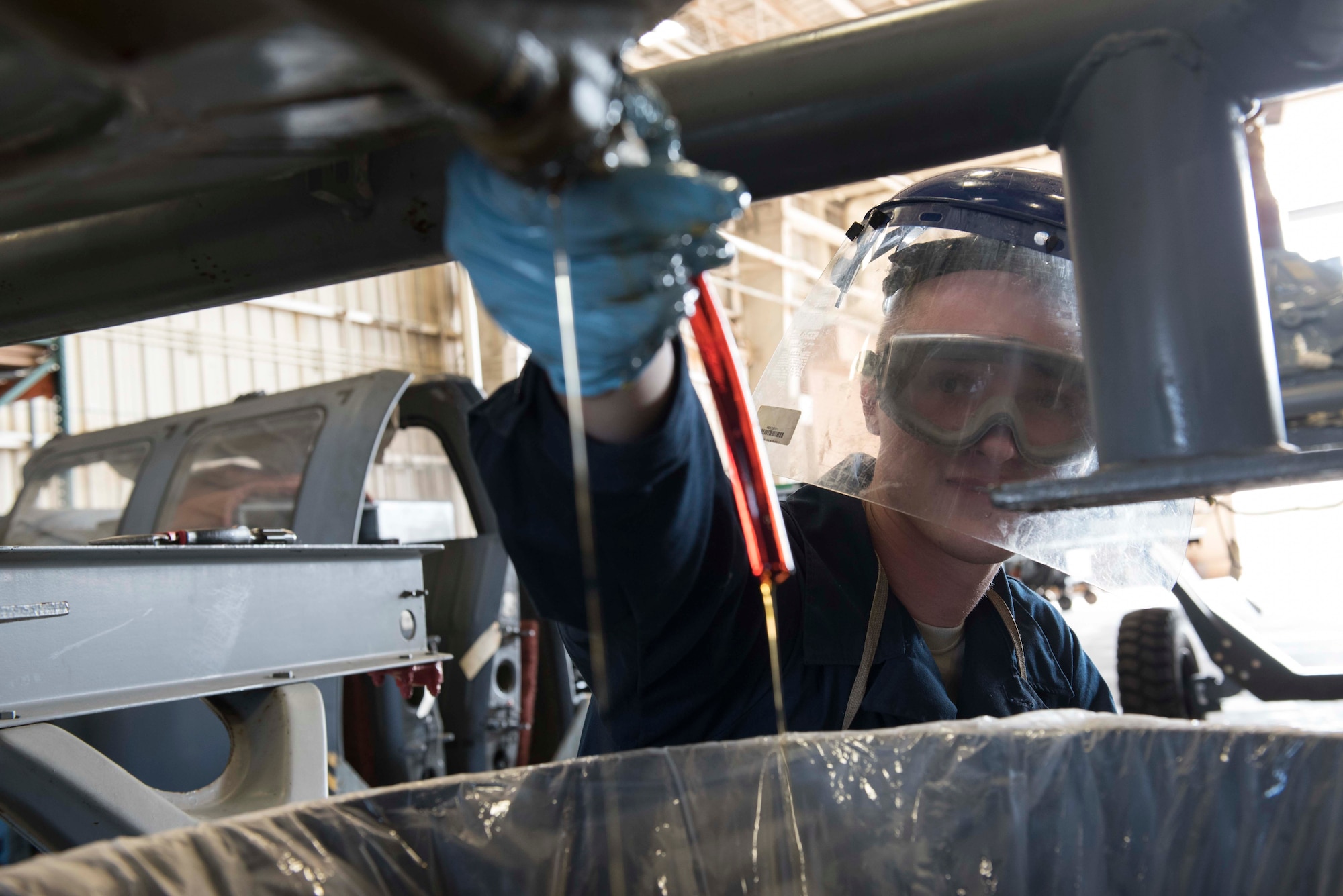 U.S. Air Force Airman 1st Class Sean Rippens, 33rd Helicopter Maintenance Unit HH-60G Pavehawk crew chief, drains the main gear box during a phase inspection at Kadena Air Base, Japan. A phase inspection or 600-hour inspection ensures that the aircraft stays maintained, serviceable and mission ready. (U.S. Air Force photo by Senior Airman Omari Bernard/Released)