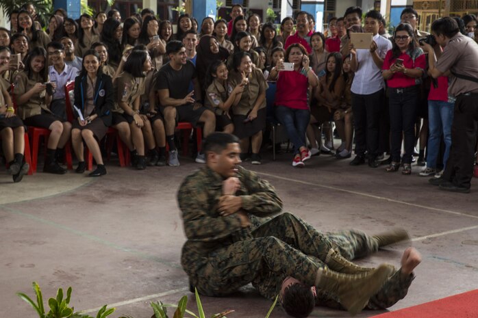 U.S. Marine Corps Cpl. Jonathan Castillo, an airframes mechanic with Marine All-Weather Fighter Attack Squadron (VMFA (AW)) 225, performs a Marine Corps Martial Arts Program technique on Cpl. Zachary Gustin, an airframes mechanic with VMFA (AW) 225, at Sekolah Menengah Atas Negeri 1 High School in Manado, Indonesia, Nov. 4, 2016. As part of a community relations event, the visit offered service members the opportunity to engage in cultural exchanges and build relationships within the local community. To begin the event, students were afforded the opportunity to ask the Marines and Sailors questions. Later, Marines demonstrated Marine Corps Martial Arts Program techniques and Petty Officer 2nd Class Billy Dorn, a squadron corpsman with VMFA (AW) 225, showed the students how to apply a tourniquet. (U.S. Marine Corps photo by Cpl. Aaron Henson)