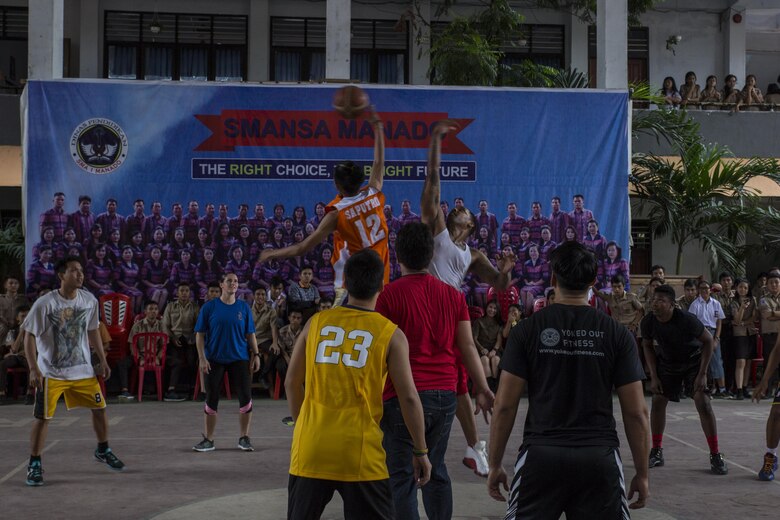 U.S. Navy Petty Officer 2nd Class Billy Dorn, a squadron corpsman with Marine All-Weather Fighter Attack Squadron (VMFA (AW)) 225, and a Sekolah Menengah Atas Negeri 1 High School student jump for a basketball in Manado, Indonesia, Nov. 4, 2016. As part of a community relations event, the visit offered service members the opportunity to engage in cultural exchanges and build relationships within the local community. The Marines and Sailors then played basketball against the students, losing 32-26 after completing two games. Service members then intermixed with the students and played one more game before finishing the event. (U.S. Marine Corps photo by Cpl. Aaron Henson)