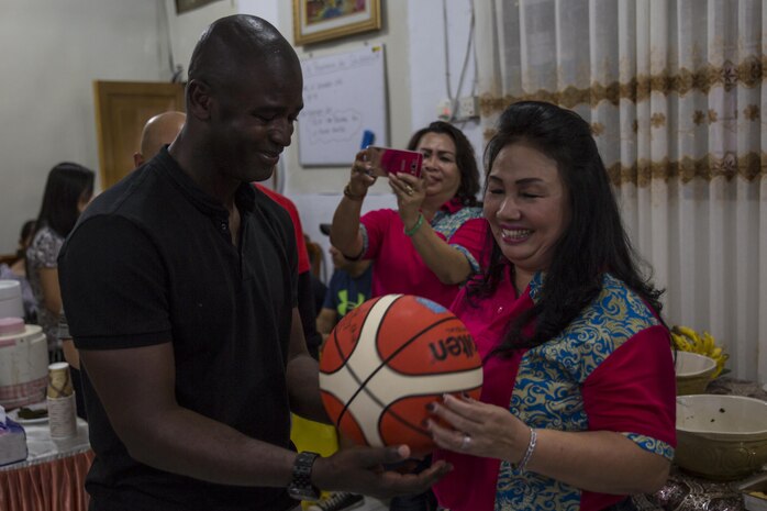 U.S. Marine Corps Sgt. Maj. Delwin K. Ellington, sergeant major of Marine All-Weather Fighter Attack Squadron (VMFA (AW)) 225, presents a signed basketball to Deysie Lumowa, the head mistress at Sekolah Menengah Atas Negeri 1 High School in Manado, Indonesia, Nov. 4, 2016. As part of a community relations event, the visit offered service members the opportunity to engage in cultural exchanges and build relationships within the local community. At the end of the event, Marines and Sailors exchanged gifts with Lumowa, showing each other’s appreciation. (U.S. Marine Corps photo by Cpl. Aaron Henson)