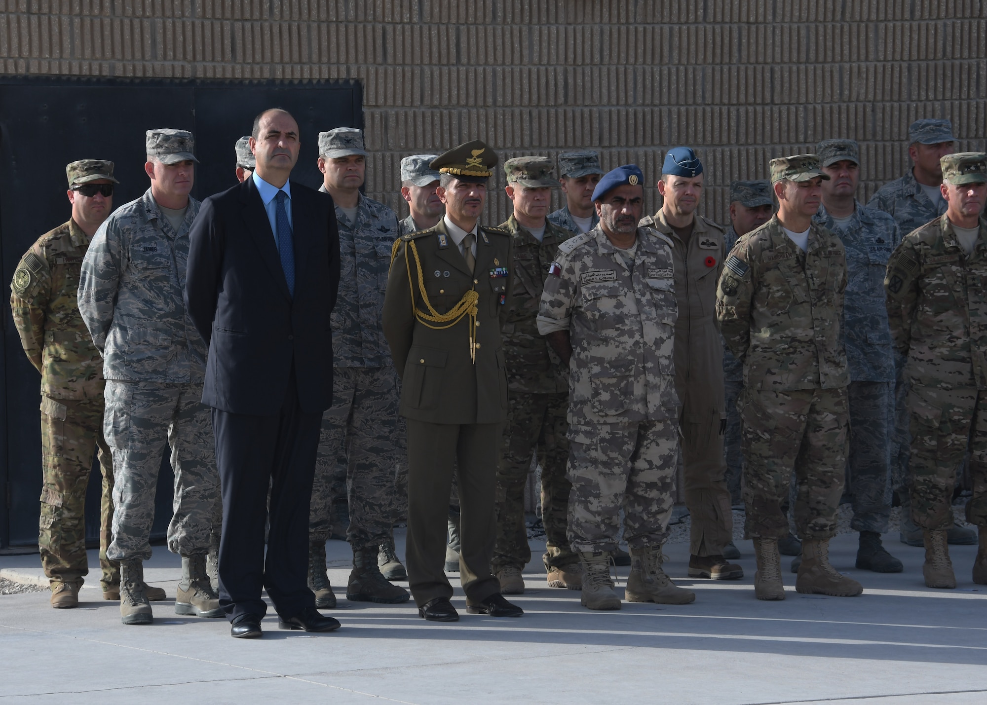 Distinguished guests and representatives from across Al Udeid Air Base, Qatar, stand together during a ceremony Nov. 4, 2016. The ceremony was in recognition of Italian Armed Forces Day and involved the raising of the Italian flag, as well as a moment of silence for those who served in the Armed Forces. (U.S. Air Force photo by Senior Airman Miles Wilson)