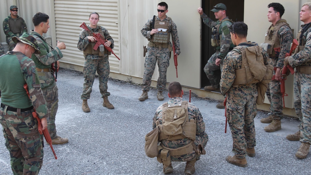 Marine critical skills operators conduct an after action debrief with Marines from the 24th Marine Expeditionary Unit's law enforcement detachment, Nov. 2, 2016. The Marines conducted training together in order to refine the detachment's urban patrolling and combat skills proficiency as part of their Realistic Urban Training exercise. The MARSOC Raiders utilized the experience to further develop their coaching and mentoring skills, using the detachment as a notional foreign partner nation force.