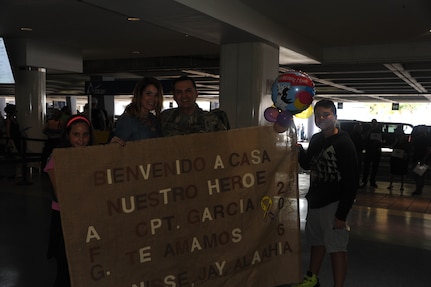 Members of the 271st HRC Casualty Liaison Team were welcomed back to the island by 1st Mission Support Leadership and their families after their deployment to Afghanistan on November 4.
(Left to Right) Alaahia Gotiy Berrios, Dennise Berrios, Capt. Orlando Garcia, Jay Gotiy Berrios.