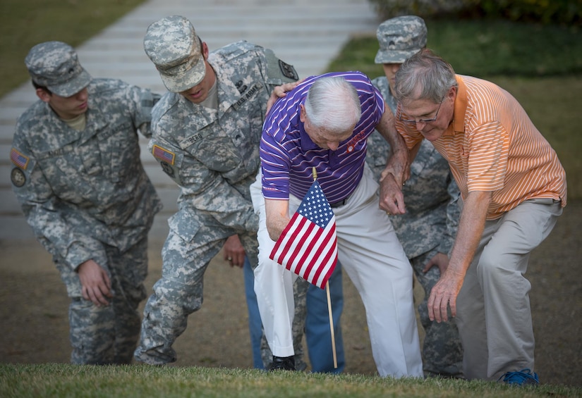 Retired U.S. Army Col. Ben Skardon, 99, a survivor of the Bataan Death March, gets help placing a flag on Otis Morgan’s stone on Clemson University’s Scroll of Honor, Nov. 3. 2016. Morgan was a fellow Clemson alum who helped save Skardon’s life while they were both interred in a Japanese prisoner of war camp. Morgan did not survive the war.  (U.S. Army photo by Staff Sgt. Ken Scar)