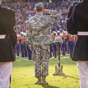 A cadet with Clemson University’s Reserve Officers’ Training Corps salutes a fallen soldier battle cross as the Clemson Tiger Band plays Taps before the Military Appreciation Game in Memorial Stadium, Nov. 5, 2016. (U.S. Army photo by Staff Sgt. Ken Scar)