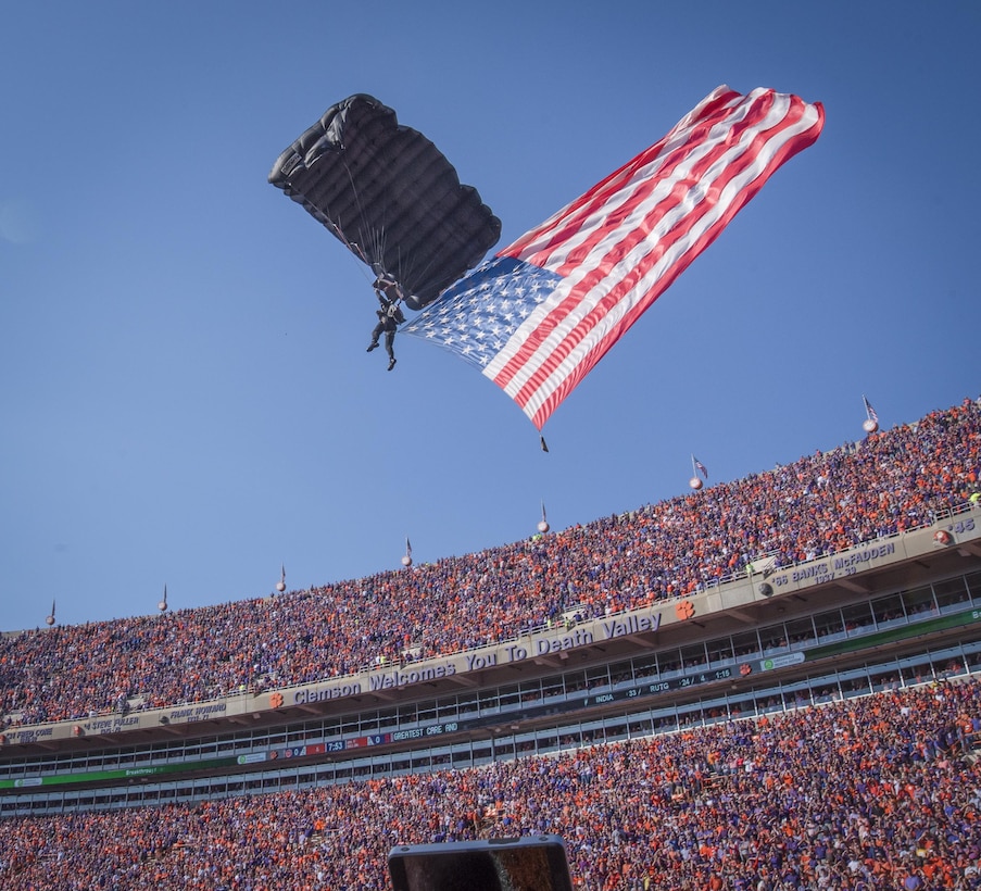 A paratrooper with the U.S. Army Special Forces Association Parachute Team from Fort Bragg flies the American flag into Clemson University’s Memorial Stadium before the kick-off of the Military Appreciation Game, Nov. 5, 2016. (U.S. Army photo by Staff Sgt. Ken Scar)
