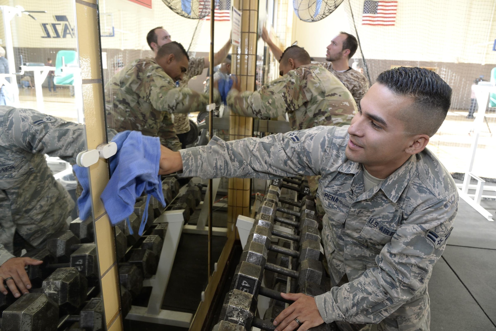 Airman 1st Class Armando Pena, 649th Munitions Squadron, cleans mirrors in the newly remodeled gymnasium at the George E. Whalen Veterans Affairs Medical Center in Salt Lake City, Nov. 3. The ‘Commitment to Service’ initiative includes all 30 NBA teams and their local military personnel who perform a local service project each year around Veterans Day, which benefits current and retired service members and their families. (U.S. Air Force photo by Todd Cromar)