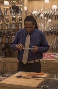 Veteran Reginald "Reggie" Des’Ravines examines knives as he shops for the perfect culinary utensils during his VIP shopping experience at Sur La Table, Charlotte N.C. Reggie received a VIP shopping experience and the opportunity to serve distinguished guests with his personal menu at The Fig Tree restaurant, Oct 27. (US. Army Reserve Photo by Spc. Tynisha L. Daniel, 108th Training Command (IET), Public Affairs)