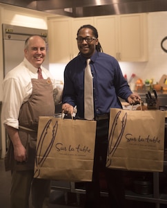 Veteran Reginald "Reggie" Des’Ravines and Assistant Manager Paul Close pose for camera after his VIP shopping experience at Sur La Table, Charlotte N.C. Reggie received a VIP shopping and the opportunity to serve distinguished guests with his personal menu at The Fig Tree restaurant, Oct 27. (U.S. Army Reserve Photo by Spc. Tynisha L. Daniel, 108th Training Command (IET), Public Affairs)