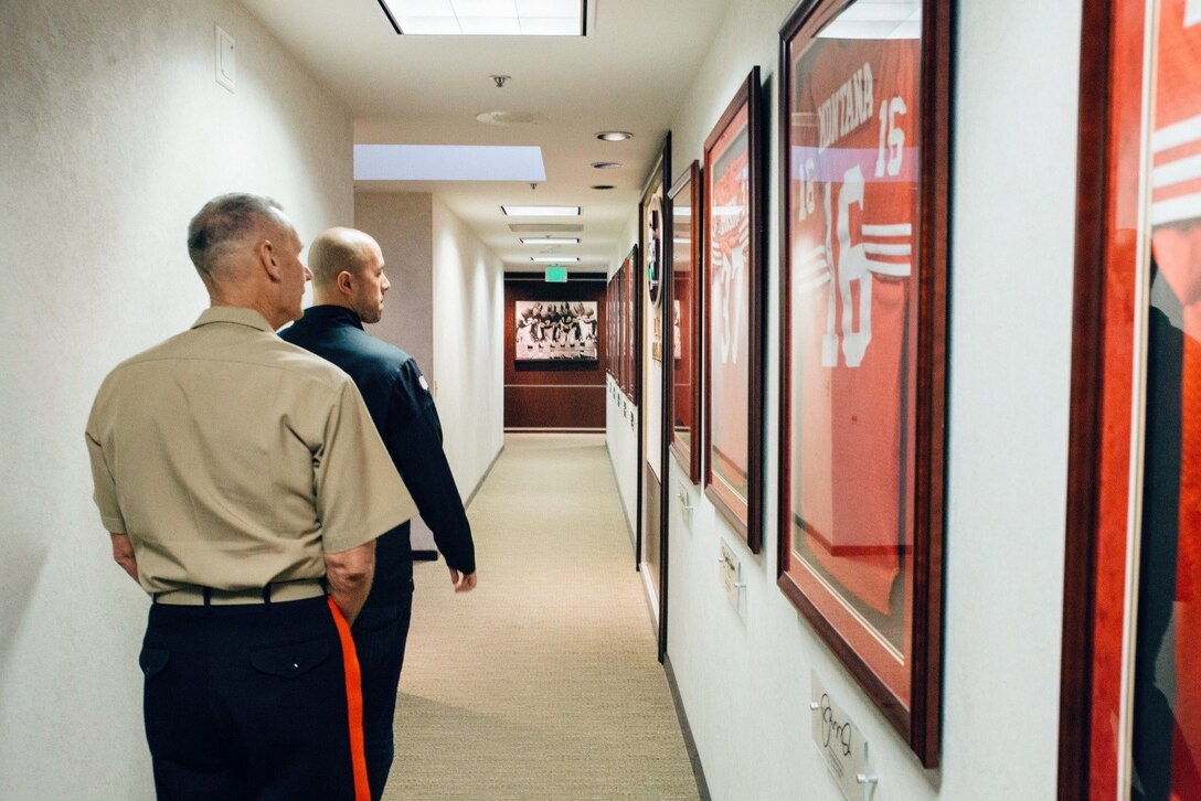 Lieutenant General Rex C. McMillian, commander of Marine Forces Reserve and Marine Forces North and Brandon Moreno, the community relations manager for the 49ers, walk down the hallway of Levi’s Stadium where retired jersey numbers are displayed, including number 16 for Joe Montana, Nov. 4, 2016.  McMillian was invited to observe a 49ers’ practice session in preparation for Sunday’s “Salute to Service” game against the New Orleans Saints at Levi’s Stadium. The half-time show of Sunday’s game will recognize the Marine Forces Reserve Centennial. Today, approximately 500 Reserve Marines are providing fully integrated operational support to Fleet and Combatant Commanders around the world.  For more information on the history and heritage of Marine Forces Reserve as well as current Marine stories and upcoming Centennial events, please visit www.marines.mil/usmcr100. (U.S. Marine Corps photo by Lance Cpl. Dallas Johnson)