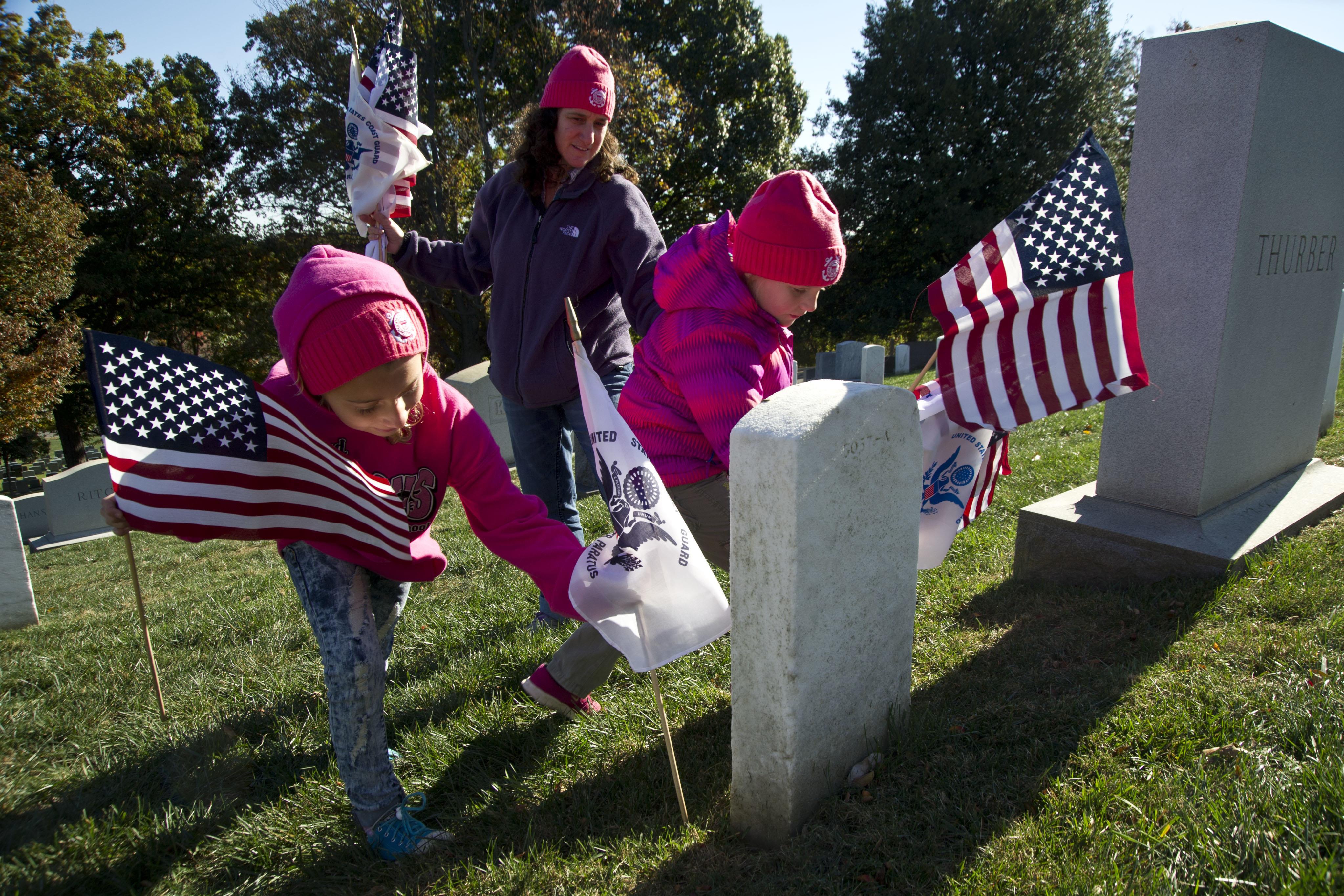 Coast Guard member Melissa Ransom and her daughters partitipate in the annual Flags Across America event at Arlington National Cemetery.