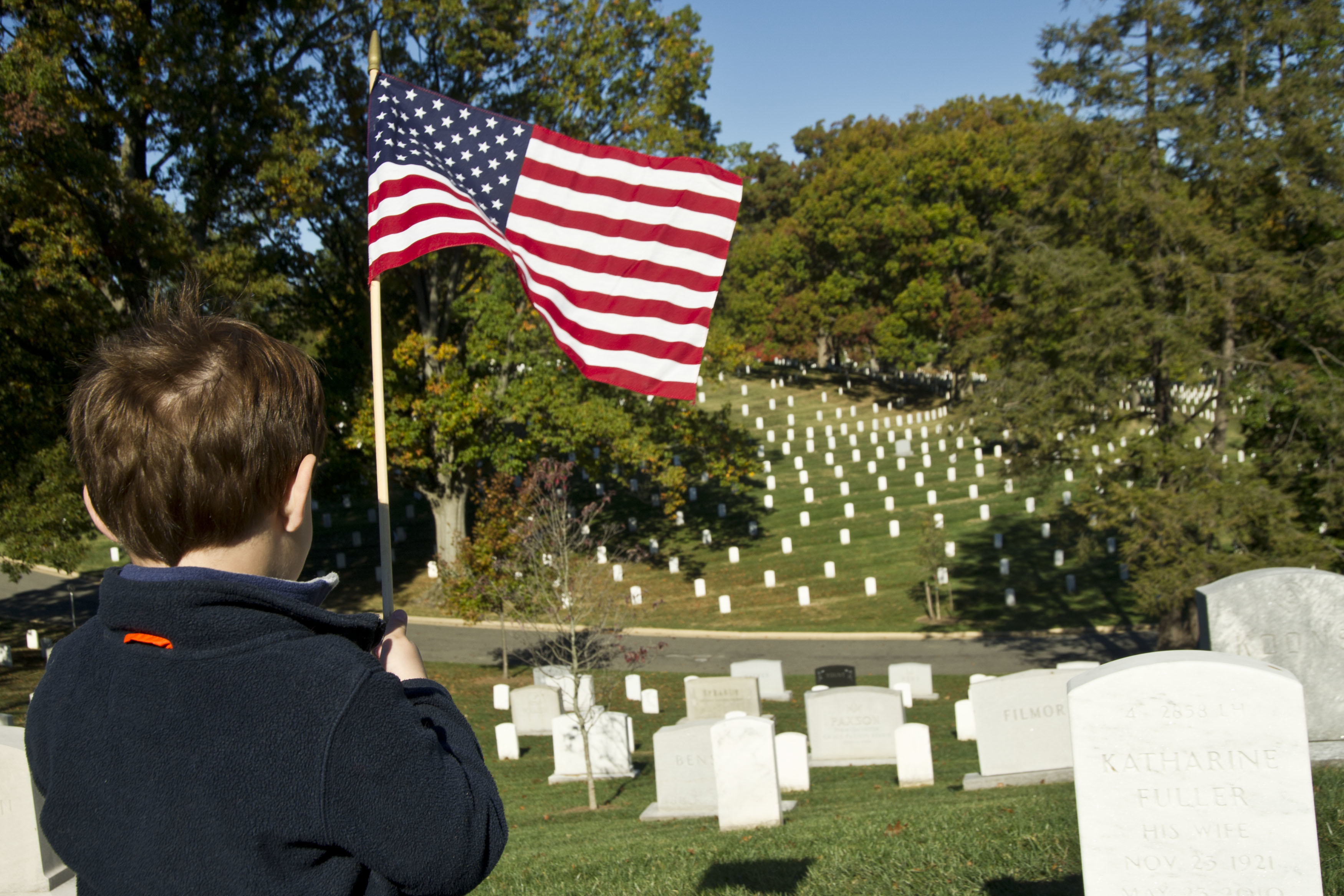 A Coast Guard family member, four-year-old Alex, takes part in the annual Flags Across America event at Arlington National Cemetery