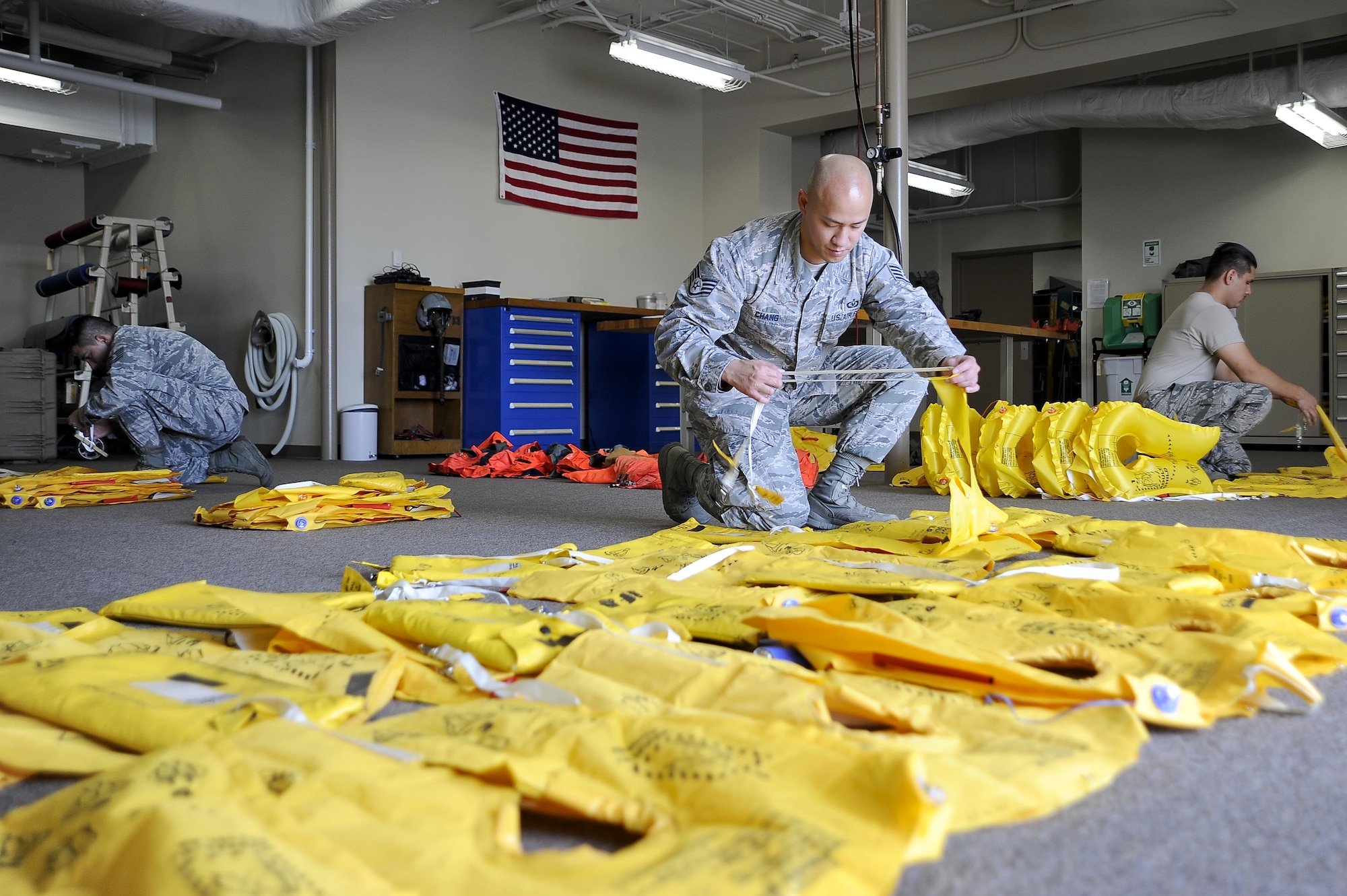 Tech. Sgt. Steven Gomez, left, Staff Sgt. Leader Chang, center, and Airman 1st Class Ysaak Hemenway, right, aircrew flight equipment (AFE) technicians with the 6th Operations Support Squadron, inspect aircraft life vests at MacDill Air Force Base, Fla., Nov. 2, 2016. Aircrew flight equipment Airmen inspect equipment based on inspection cycles, which requires certain items to be inspected periodically based on their technical orders. (U.S. Air Force photo by Airman 1st Class Mariette Adams)