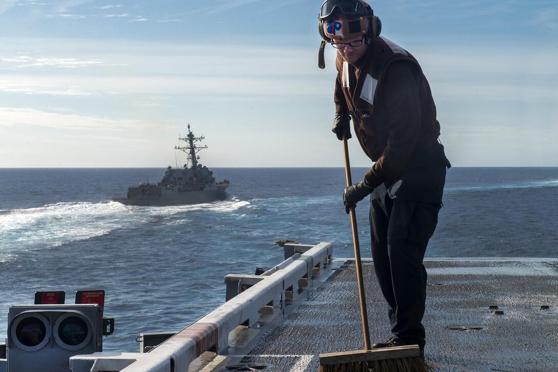 Navy Petty Officer 3rd Class Brannon Murphy cleans the flight deck of the aircraft carrier USS Carl Vinson as it conducts a simulated strait transit with the Carl Vinson Carrier Strike Group in the Pacific Ocean, Oct. 29, 2016. Navy photo by Petty Officer 3rd Class Sean Castellano 