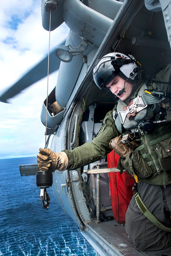 Navy Petty Officer 3rd Class Kyle O’Brien handles a rescue winch during a routine plane guard flight in a MH-60S Sea Hawk helicopter assigned to Helicopter Sea Combat Squadron over the Pacific Ocean near the aircraft carrier USS Carl Vinson in the Pacific Ocean, Oct. 30, 2016. Navy photo by Petty Officer 3rd Class Zackary Alan Landers