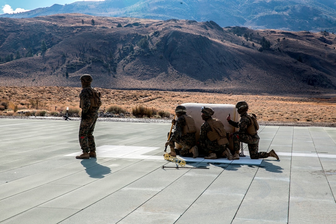 U.S. Marines with Combat Logistics Battalion 15, 1st Marine Logistics Group, and 3rd Battalion, 4th Marine Regiment, 1st Marine Division, wait by a 500-gallon drum of water to conduct a Helicopter Support Team drill at Mountain Warfare Training Center, Bridgeport, Calif., Oct. 25, 2016. The drum was taken into the Sierra Mesa Mountains to support Marines who are conducting field operations during Mountain Exercise 6-16. (U.S. Marine Corps photo by Lance Cpl. Adam Dublinske)