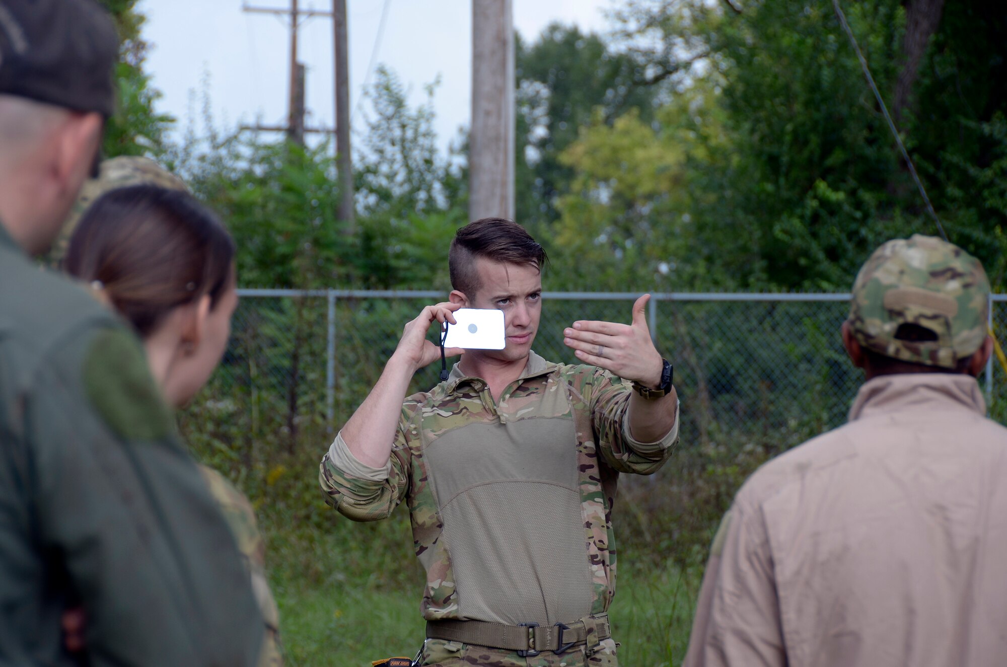 Staff Sgt. Jacob Nespor, SERE specialist for the 445th Operations Support Squadron, demonstrates the proper technique for using a signal mirror to Airmen of the 445th Aeromedical Evacuation Squadron during Combat Survival Training Oct. 2nd, 2016, at the Warfighter Training Center here. During the training the Airmen were instructed on land navigation, shelter building, signaling, communication, evasion, recovery and exfill. (U.S. Air Force photo/Staff Sgt. Joel McCullough)