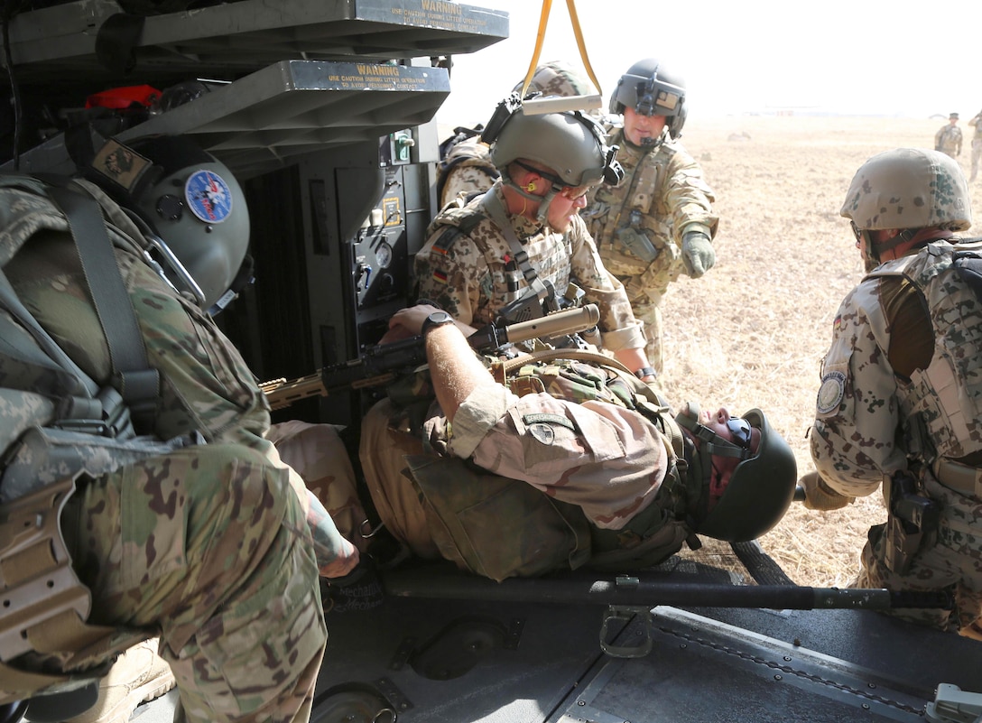 A U.S. Army flight medic crew assigned to Company C, 1st General Support Aviation Battalion, 111th Aviation Regiment, Task Force Dragon, instruct coalition soldiers exiting procedures during a hot-load litter carry out of an HH-60M Black Hawk helicopter during a coalition medevac and hoist training exercise at Erbil, Iraq, Aug. 20, 2016. This training was conducted to teach and familiarize German, Dutch, and Finnish soldiers with U.S. Army medevac equipment and procedures. More than 60 Coalition partners have committed themselves to the goal of eliminating the threat posed by the Islamic State of Iraq and the Levant and have contributed in various capacities to the effort to combat ISIL. (U.S. Army photo by Sgt. Kalie Jones/Released)