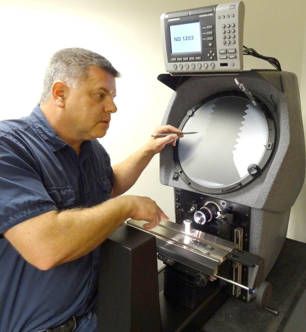 Test coordinator Jeff Grady demonstrates the dimensional test capability of an optical comparator. 
