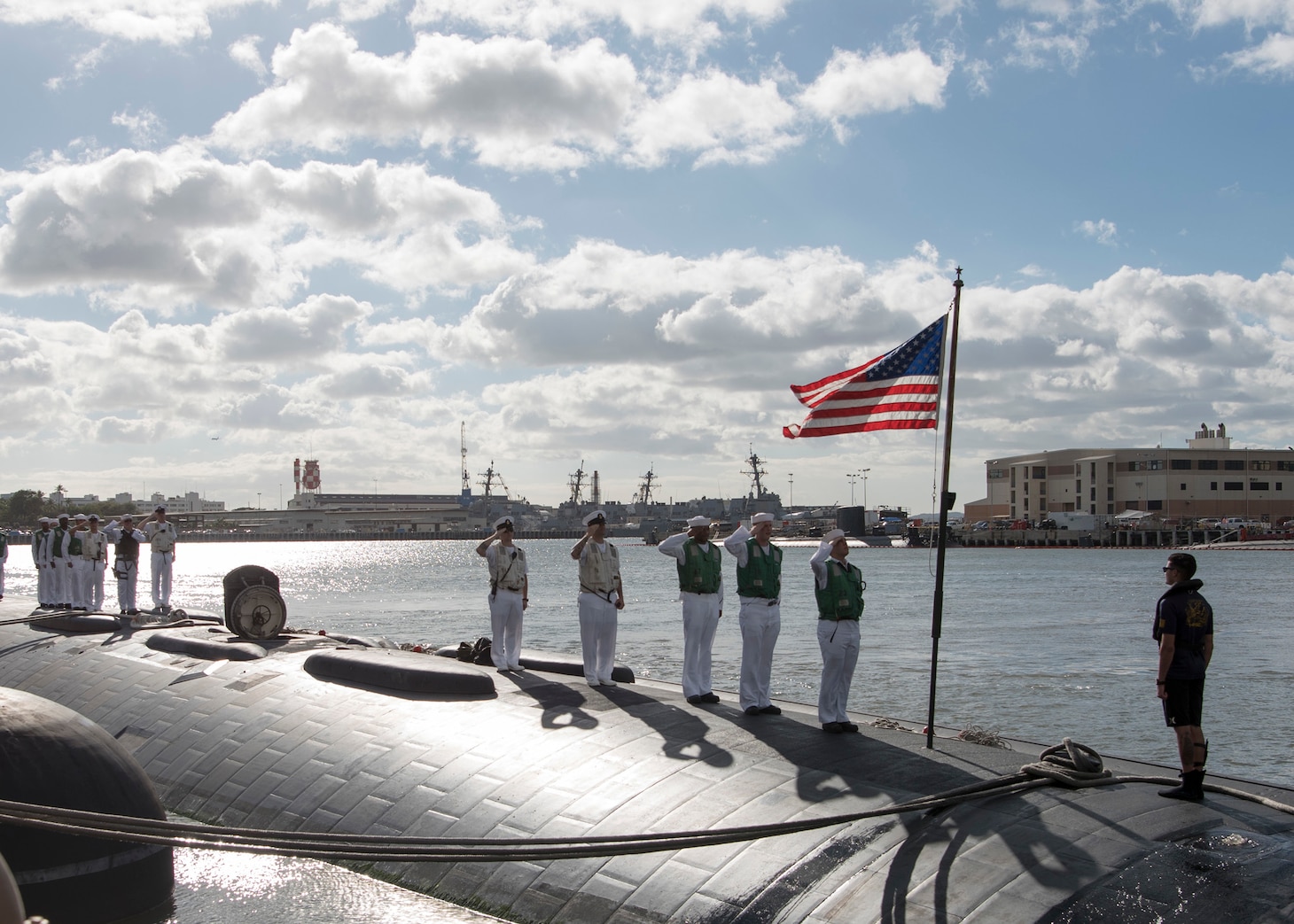 161103-N-LY160-124 JOINT BASE PEARL HARBOR-HICKAM, Hawaii (November 3, 2016) Sailors assigned to the Los Angeles-class fast-attack submarine USS Greeneville (SSN 772) salute the ensign following the completion of her six-month deployment to the Western Pacific Ocean in Joint Base Pearl Harbor-Hickam. (U.S. Navy photo by Petty Officer 2nd Class Michael H. Lee/Released)