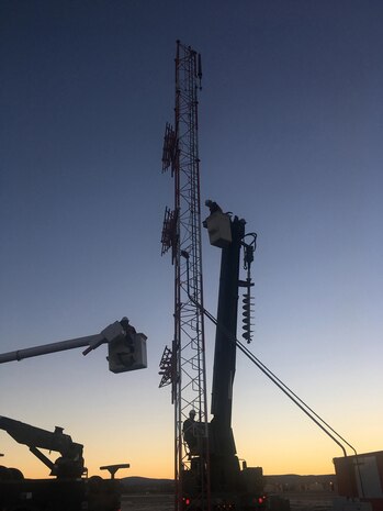 U.S. Air Force Airmen from the 354th Civil Engineer Squadron are lifted up to work on an antenna mast Oct. 6, 2016, at Eielson Air Force Base, Alaska. The antenna mast needed to be shortened to improve safety and reduce airfield obstructions. 