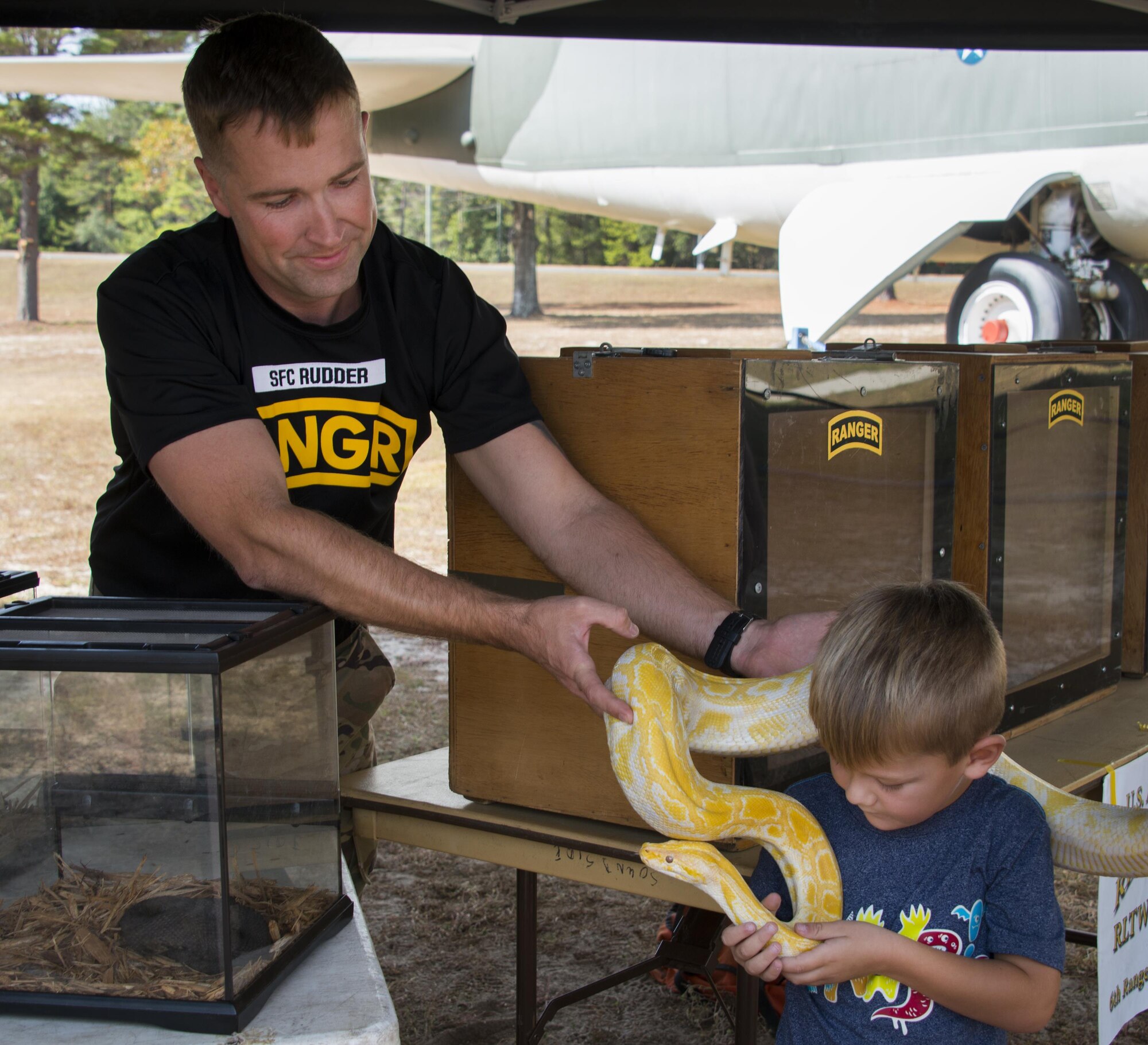 Sgt. 1st Class Robert Rudder, 6th Ranger Training Battalion, hands an albino Burmese python to a child attending the Air Force Armament Museum’s Northwest Florida 50th Vietnam War Commemoration Celebration event Nov. 5 at Eglin Air Force Base, Fla.  Event activities included a military working dog demonstration, explosive ordnance removal robots, reptile display, a speaker’s panel and an AC-130 tour.  (U.S. Air Force photo/Kristin Stewart)