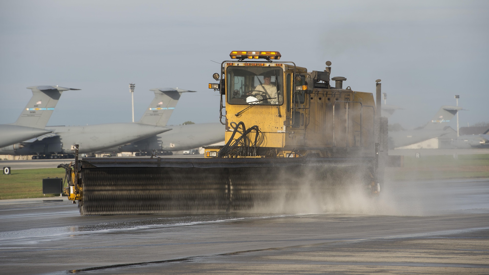 An Oshkosh Snow Broom conducts rubber removal operations on Runway 14-32 Nov. 1, 2016, at Dover Air Force Base, Del. Normally used for snow removal on the airfield, snow brooms are often repurposed for rubber removal operations. (U.S. Air Force photo by Senior Airman Zachary Cacicia)